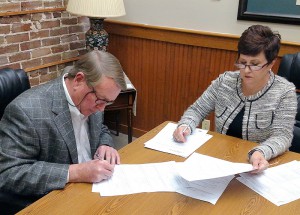 LUMCFS Board Chair Robert Temple executes purchase documents to acquire property for a permanent Home.